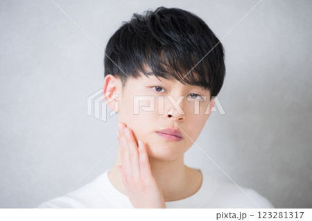 頬に手を触れてカメラ目線の若い20代の男性 美容やビューティーイメージ 頬に手を触れてカメラ目線の若い20代の男性 美容やビューティーイメージ 123281317