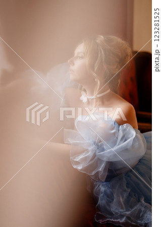 Portrait of an elegant woman in a light blue ball gown in a classic interior 123281525
