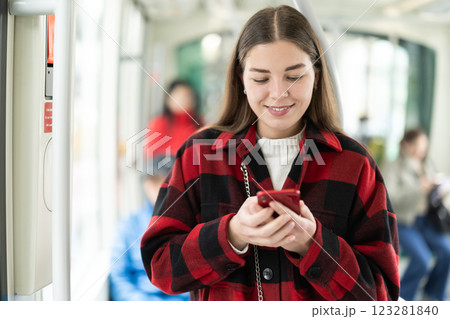 Girl with long hair standing in tram with phone 123281840