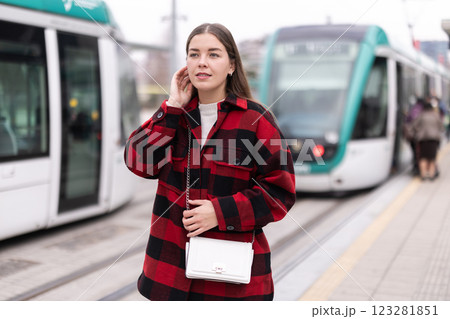 Woman standing at a tram stop Woman standing at a tram stop 123281851