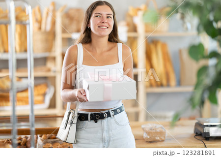 Young woman with pastries in box in bakery Young woman with pastries in box in bakery 123281891
