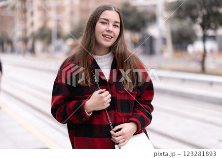 woman stands at a public transport stop 123281893