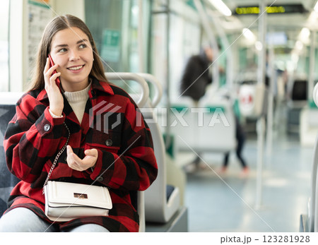 Girl sit in tram car and emotionally talks on phone, getting to work Girl sit in tram car and emotionally talks on phone, getting to work 123281928