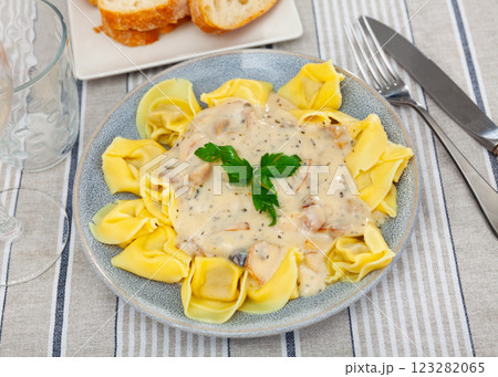 Portion of fresh ravioli is served on plate, drizzled with mushroom sauce. Decorated by parsley 123282065