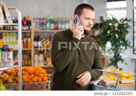 Man in the store calls on the phone. 123282165