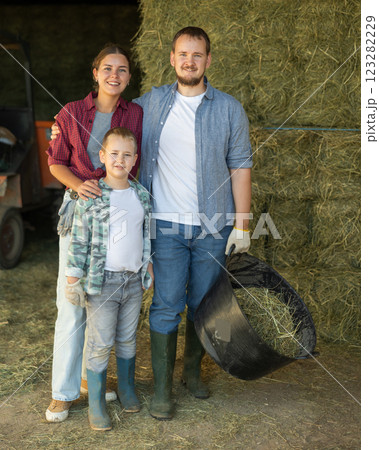 Portrait of happy family with son in backyard of horse farm, with hay in background Portrait of happy family with son in backyard of horse farm, with hay in background 123282229