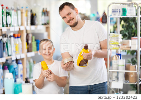 Schoolboy son and dad are choosing wood polish in store Schoolboy son and dad are choosing wood polish in store 123282422