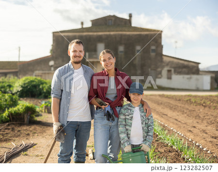 Family of farmers standing in the garden Family of farmers standing in the garden 123282507