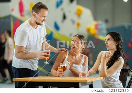 Man tries to talk to two angry women on climbing wall Man tries to talk to two angry women on climbing wall 123282580