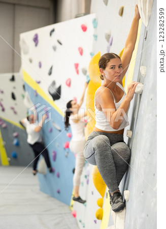 Young woman practicing rock climbing on climbing wall 123282599