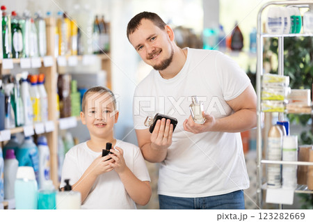 Young man and boy choosing perfume in store 123282669