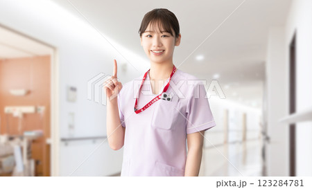 人差し指を立てて案内する笑顔の女性医療スタッフ 123284781
