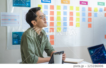 asian financial investor working in a office, analyzing financial charts and data 123286006