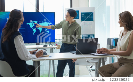 asian leader presenting a financial data and strategies in a modern office with charts and graphs displayed on a large screen 123286022
