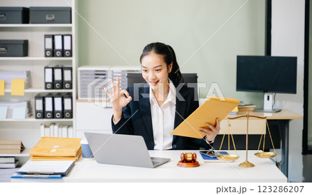 female lawyer celebrating success with documents at a desk, featuring a gavel, scales of justice, female lawyer celebrating success with documents at a desk, featuring a gavel, scales of justice, 123286207