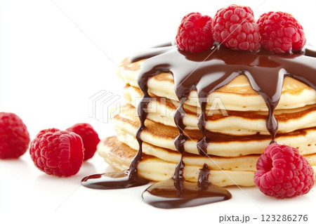Stack of pancakes dripping with chocolate and topped with raspberries 123286276