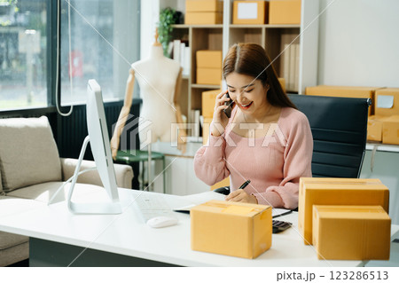 Young businesswoman managing online sales and shipping from a modern home office. 123286513