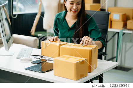 Business owner woman prepare parcel box and standing check online orders for deliver 123286542