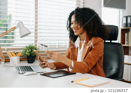 Woman using smart phone for mobile payments online shopping, omni channel, sitting on table 123286857