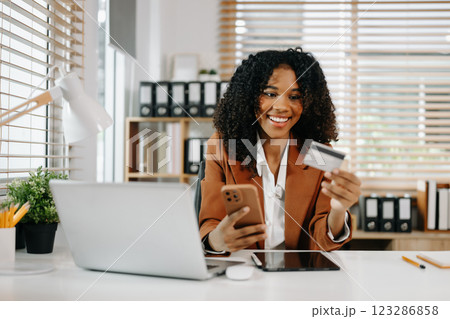 Woman using smart phone for mobile payments online shopping, omni channel, sitting on table 123286858