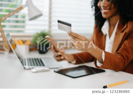 Woman using smart phone for mobile payments online shopping, omni channel, sitting on table 123286860