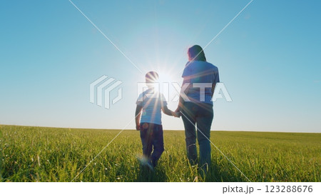 Mother And Son Walk In Open Air In Countryside. Teamwork Outdoors. Concept Of Happy Family. Son Hold Mom By Hand. Happy Family With Child Going Among Meadow. Steadicam Shot. Mother And Son Walk In Open Air In Countryside. Teamwork Outdoors. Concept Of Happy Family. Son Hold Mom By Hand. Happy Family With Child Going Among Meadow. Steadicam Shot. 123288676