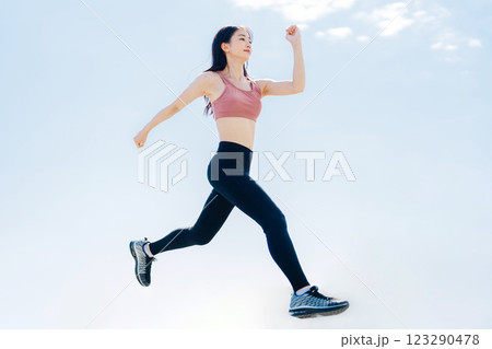 スポーツウェアでジャンプする若い女性 123290478
