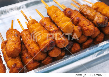 fried sausages in breadcrumbs on sticks at street market in Asia. Korean hot dog or korndog. Asian fast food fried sausages in breadcrumbs on sticks at street market in Asia. Korean hot dog or korndog. Asian fast food 123290702