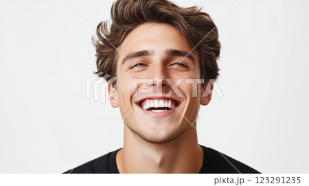 Enthusiastic young man radiates joy with a wide, genuine smile, capturing a moment of happiness and positive emotion, full of energy. 123291235