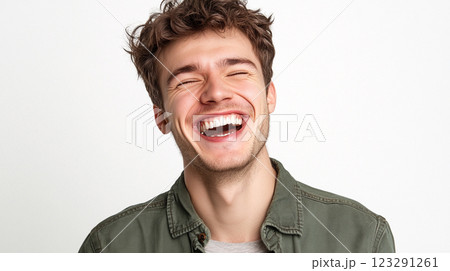 Man enjoying a hearty laugh with eyes closed. Casual style, expressive joy, creating a fun and inviting atmosphere of relatable happiness. 123291261