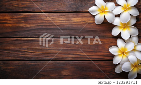 Plumeria flowers adorn a rustic wooden surface, creating a serene and natural composition. Perfect for backgrounds or tranquil themes. 123291711