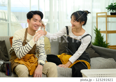Loving asian couple resting on couch after finishing their household chores Loving asian couple resting on couch after finishing their household chores 123291921