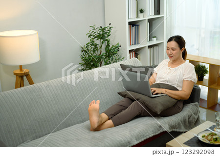 Relaxed adult woman working on laptop at home 123292098