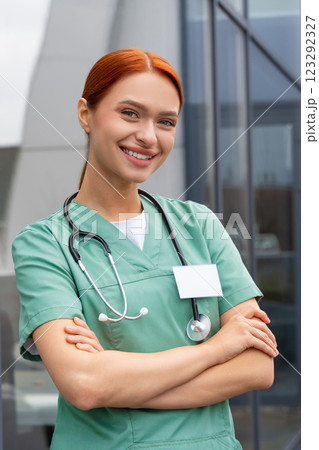 Smiling young woman wearing medical uniform with stethoscope in clinic Smiling young woman wearing medical uniform with stethoscope in clinic 123292327