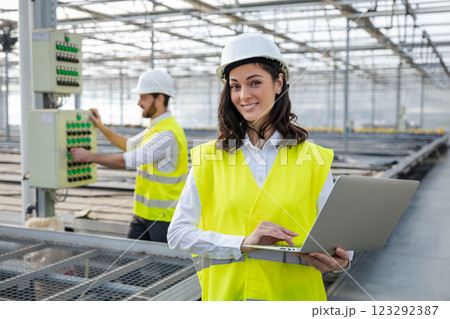 Young female engineer with a laptop checking the parameters at the construction site 123292387
