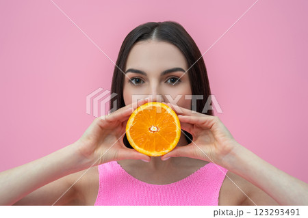 Dark-haired cute young woman holding a slice of orange in hands 123293491