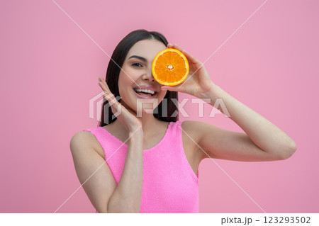 Dark-haired cute young woman holding a slice of orange in hands 123293502