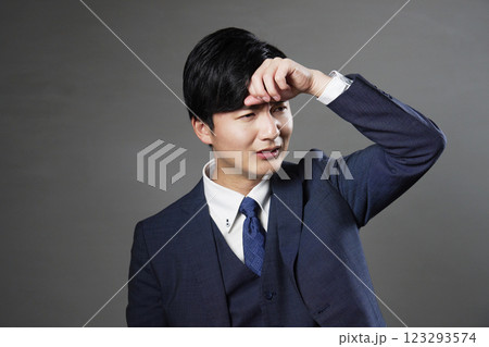 おでこに手を当てるビジネスマン　発熱　黒背景 123293574