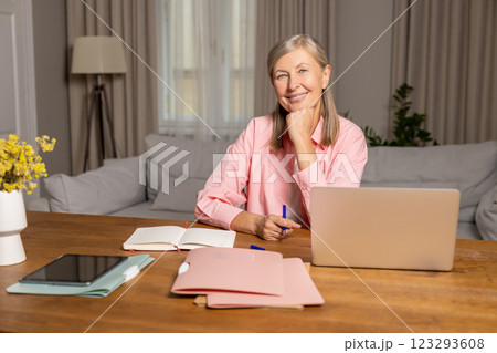 Mid aged caucasian woman sitting at the laptop and feeling inspired 123293608