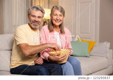Mature couple spending time together at home and eating popcorn. 123293637