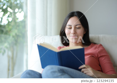 Satisfied asian woman reading a paper book at home 123294135