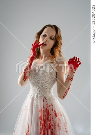 Bride with bloody hands elegantly poses in exquisite lingerie and a katana Bride with bloody hands elegantly poses in exquisite lingerie and a katana 123294328