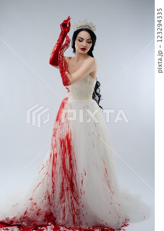 Bridal beauty in bloodstained gown with knife in dramatic setting 123294335