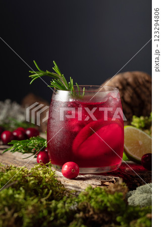 Cranberry cocktail with ice, lime, and rosemary on a old wooden board. 123294806