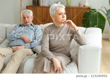 Marriage crisis relationship problems. Old couple quarreling. Sad mature disappointed woman sitting away from husband after having quarrel. Senior couple not talking having problems in relationship 123294950