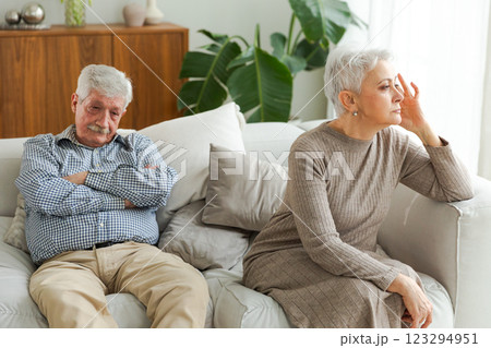 Marriage crisis relationship problems. Old couple quarreling. Sad mature disappointed woman sitting away from husband after having quarrel. Senior couple not talking having problems in relationship 123294951