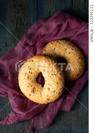 Homemade large bagels with sesame, flax and sunflower seeds on burgundy gauze, top view 123295111