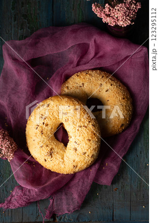 Homemade bagels with sesame, flax and sunflower seeds on burgundy gauze, top view 123295112