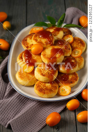 Delicious cheesecakes with delicious kumquats and citrus jam in a large oval plate 123295127