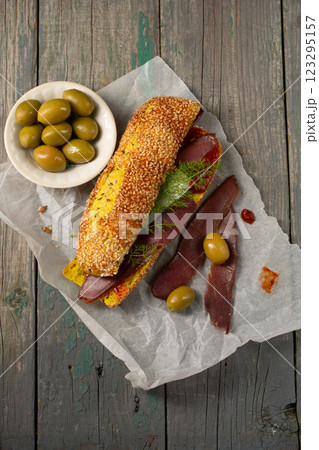 Burger with ciabatta with turmeric, bastrum and olives, top view Burger with ciabatta with turmeric, bastrum and olives, top view 123295157